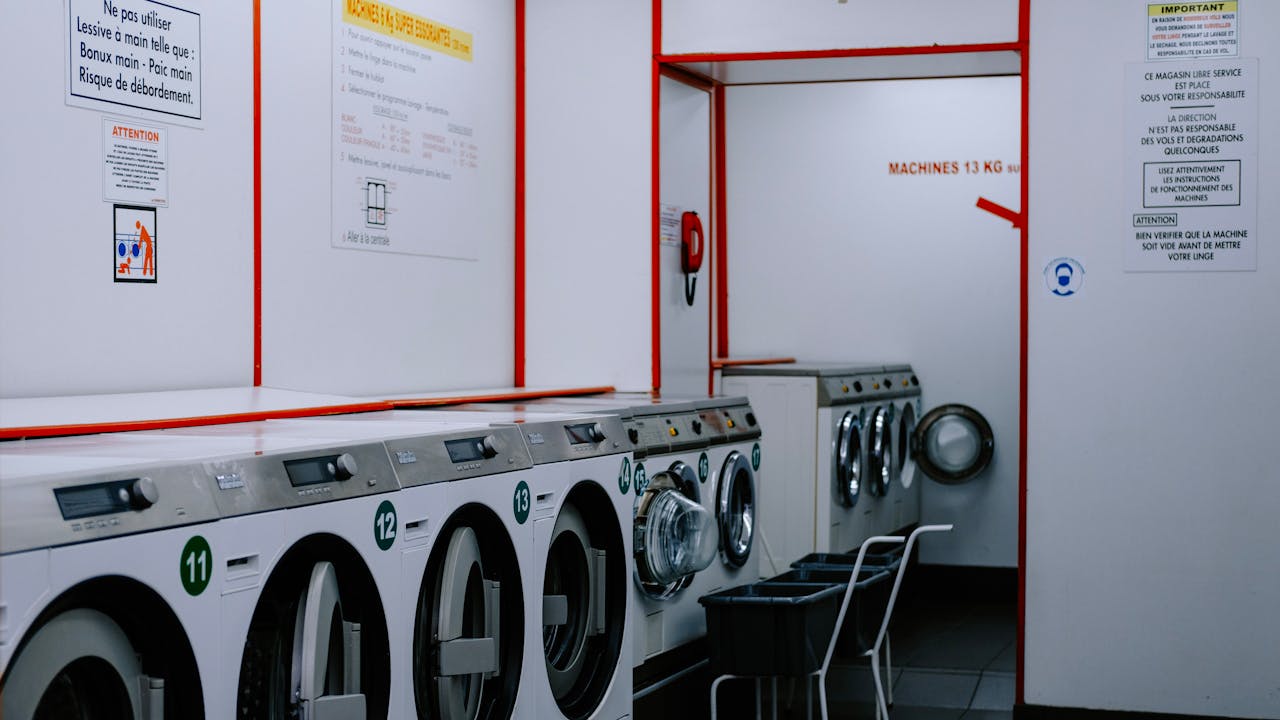 Inside a laundromat with washing machines lined up against the wall.